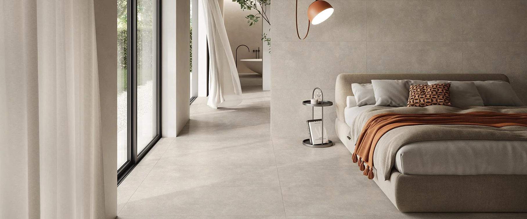 Minimalist kitchen and living space with honed stone floor tiles and a marble-look island